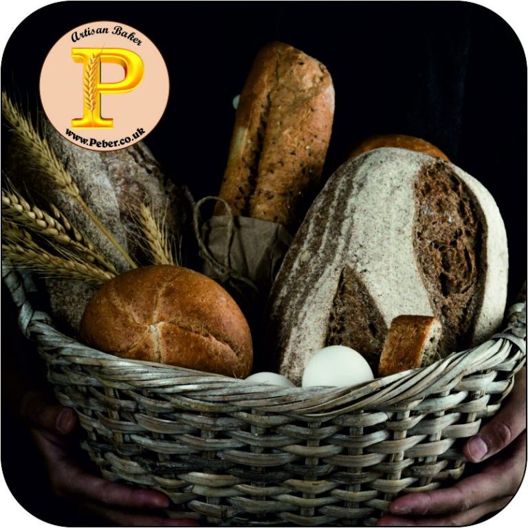 A woven basket filled with various types of bread and grains against a dark background.